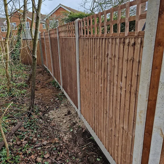 Wooden garden fence with trellis and concrete posts